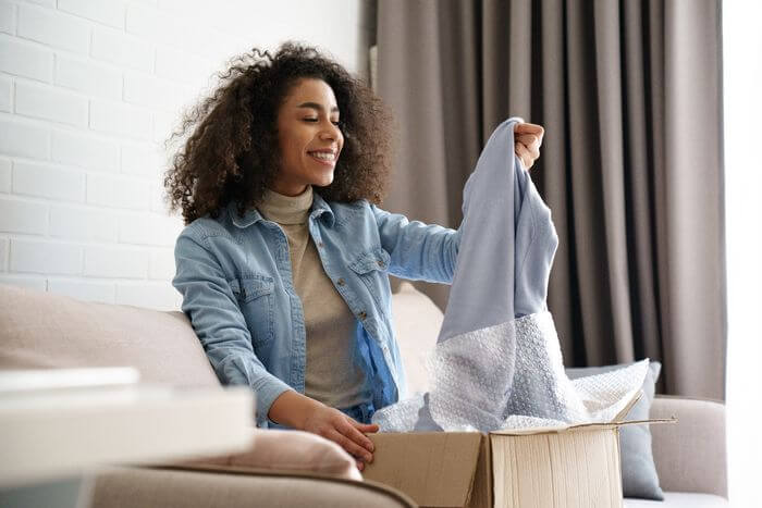 Lady unwrapping online delivery. Image supports eCommerceer podcast episode 14 
